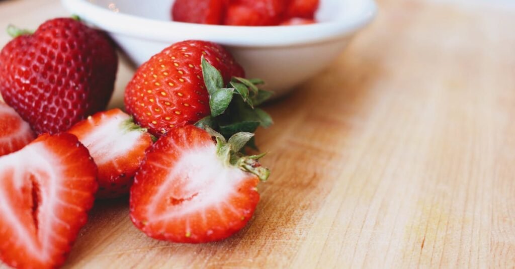 Close-up of fresh, juicy strawberries on a wooden cutting board, perfect for healthy snacking.