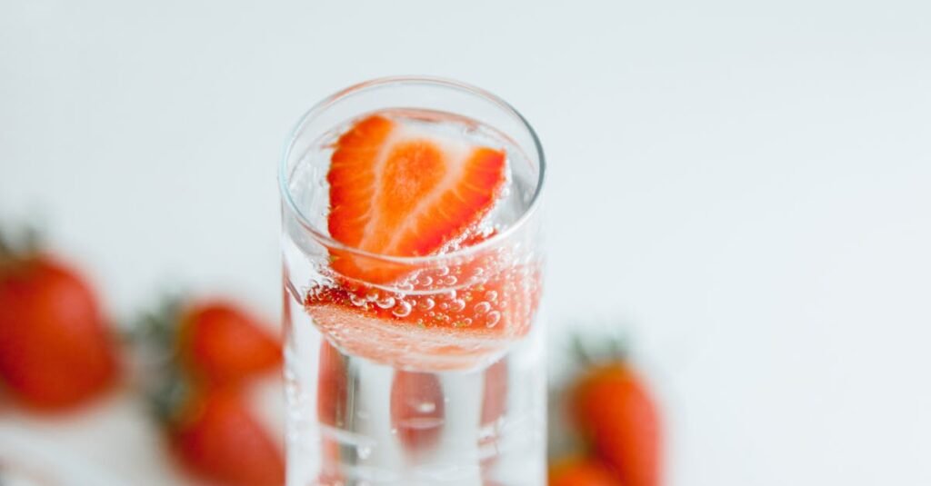 Close-up of strawberries in sparkling water, emphasizing freshness and hydration.