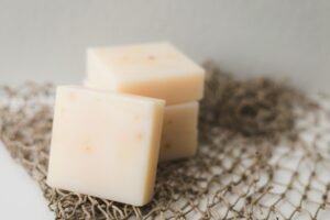 Close-up of creamy cheese blocks stacked on netting, perfect for food photography.