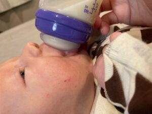 Baby drinking from a Lansinoh bottle showing a natural latch